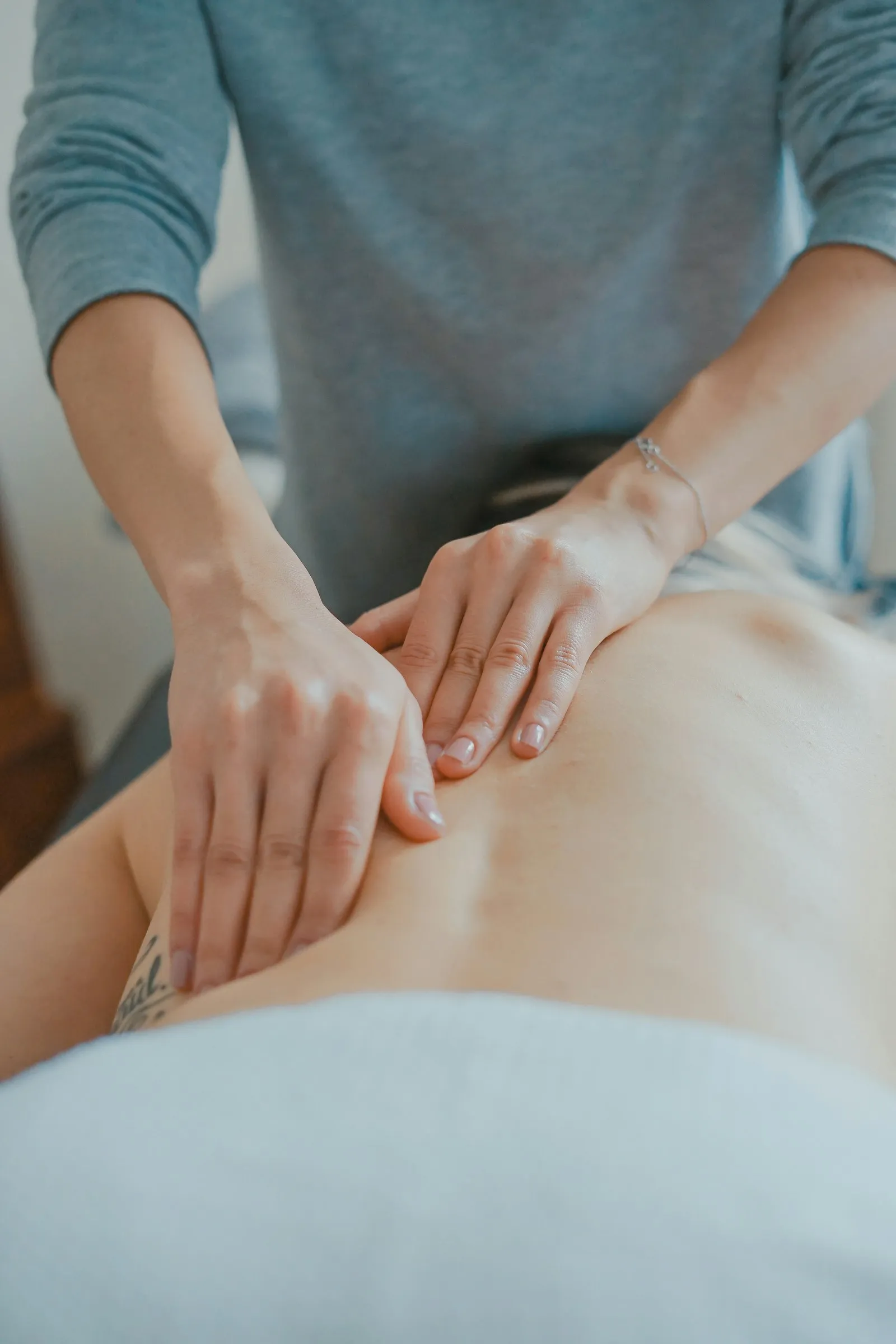 Therapist applying focused pressure to ease lower back tension