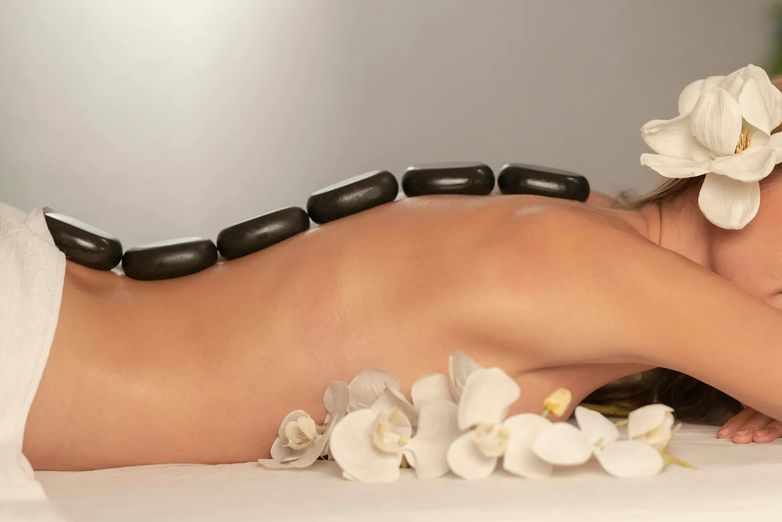 Calm, softly lit massage setting with neatly folded towels and warm tones